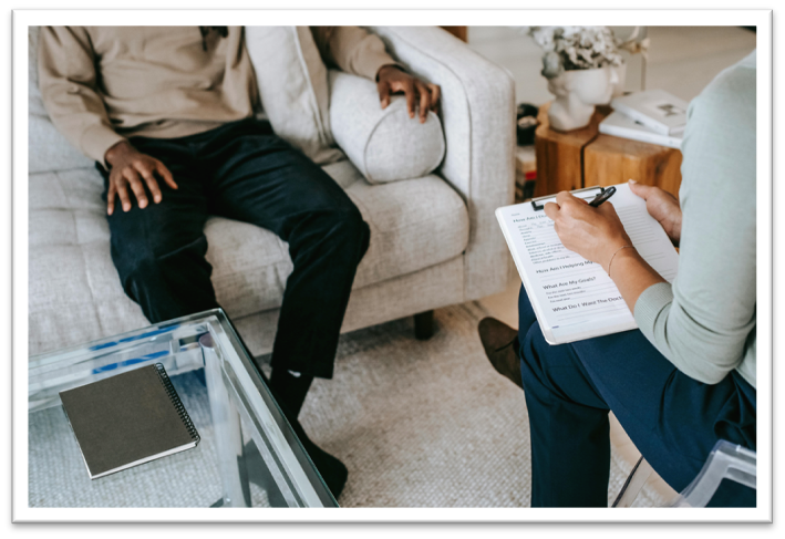 two people talking while one takes notes