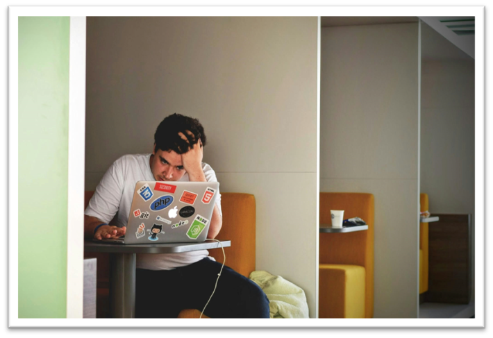 man at desk looking at computer feeling stressful 